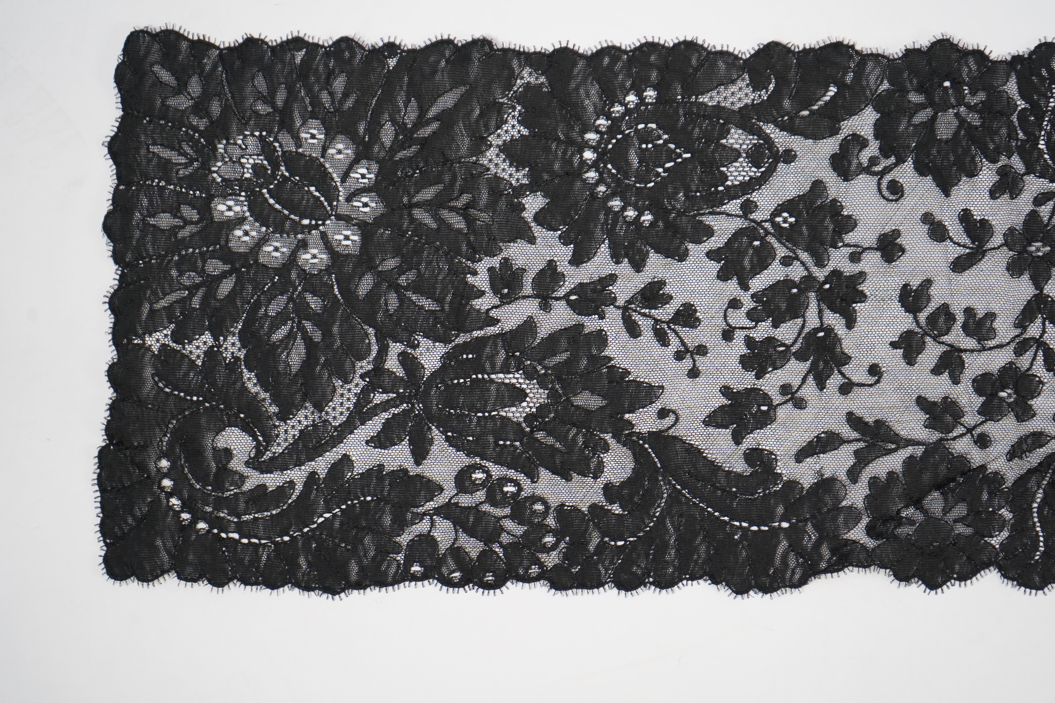 A collection of mixed machine lace: a black lace stole, two black veils, a sample of Japanese brocade, a length of metallic ribboning and various items of cream lace, ribboning 230cm long. Condition - variable poor to fa